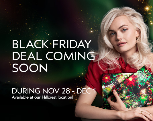 A woman holding a colorful shopping bag sits next to text announcing a Black Friday deal coming soon, with dates November 28 to December 1 at the Hillcrest location. - Gila Rut Salon | San Diego and Chula Visa, CA