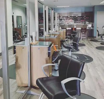 A modern hair salon with black styling chairs, wooden stations, large mirrors, and protective glass dividers. The space is clean, bright, and unoccupied. - Gila Rut Salon | San Diego and Chula Visa, CA